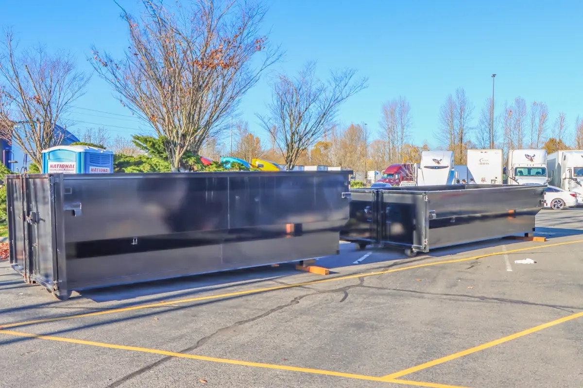 Professional dumpster rental service with roll-off container on residential driveway in New Braunfels